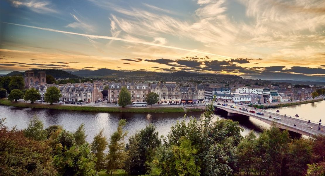 Inverness ved elvebredden i grålysningen med slottet i bakgrunnen.