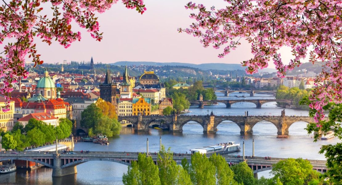 Historiske broer over Vltava-elven i Praha ved solnedgang.