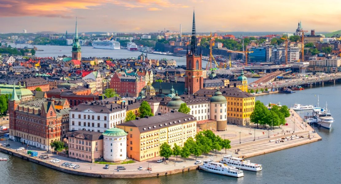 Stockholms Gamla Stan badet i gyllen solnedgangslys fra Stadshuset.