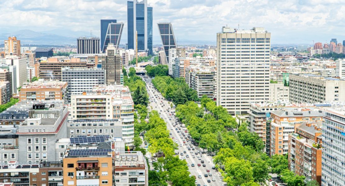 Castellana-avenyen i Madrid sentrum med Cuatro Torres på horisonten.