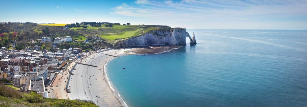 Panoramautsikt over Étretat by med strand og berømte klipper.
