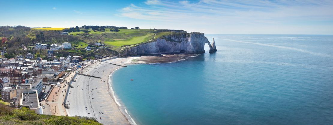 Panoramautsikt over Étretat by med strand og berømte klipper.
