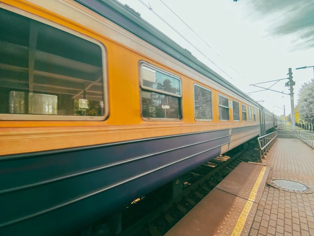 Gul og blå tog i bevegelse på jernbanestasjon i Riga, Latvia.