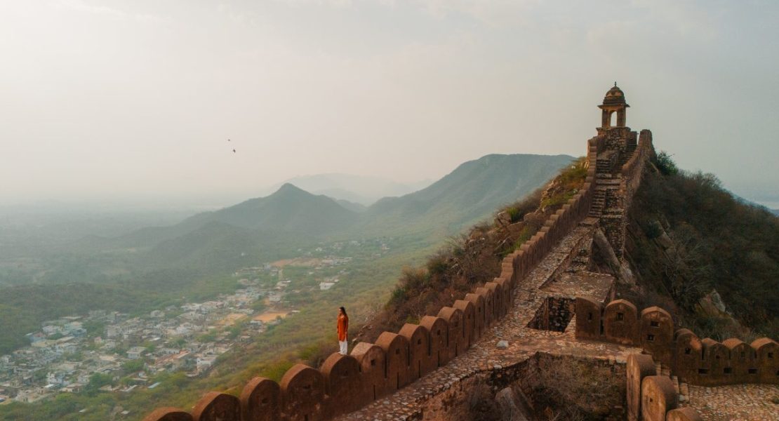 Dame går på ringmuren ved Amber-fortet i Jaipur, India.