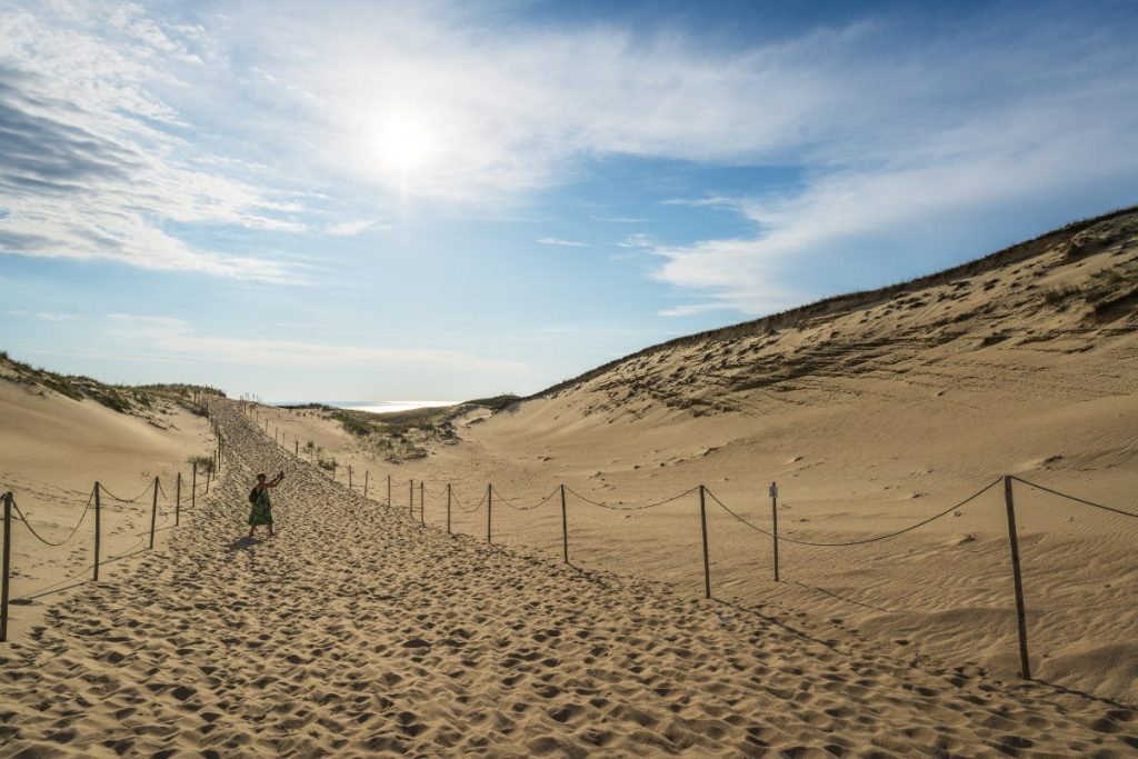 Dame går på sanddyne på Kuriske odden i Nida, Litauen.