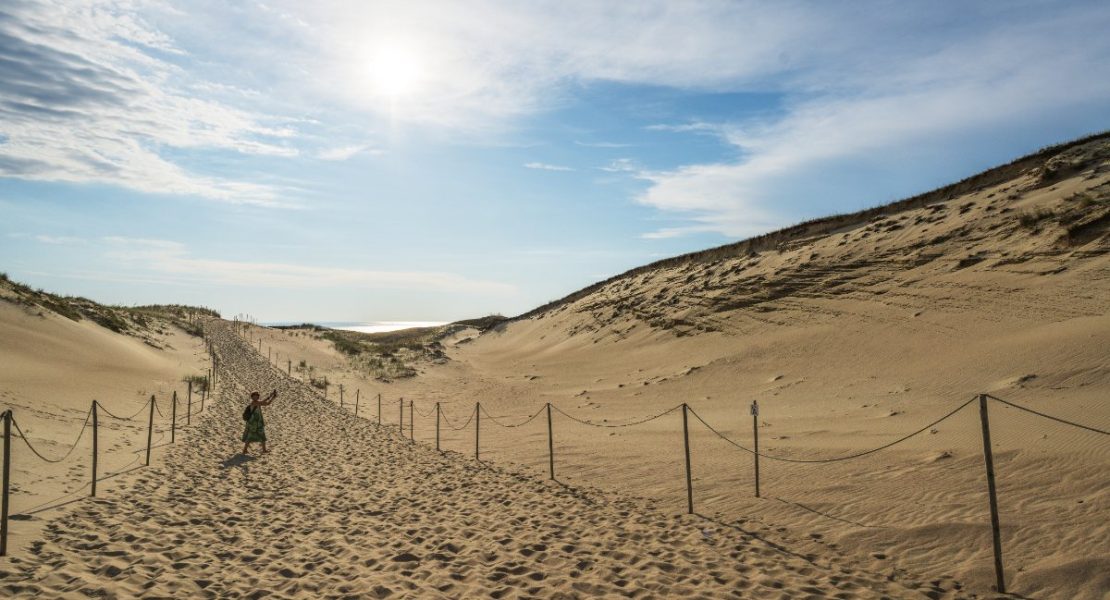 Dame går på sanddyne på Kuriske odden i Nida, Litauen.