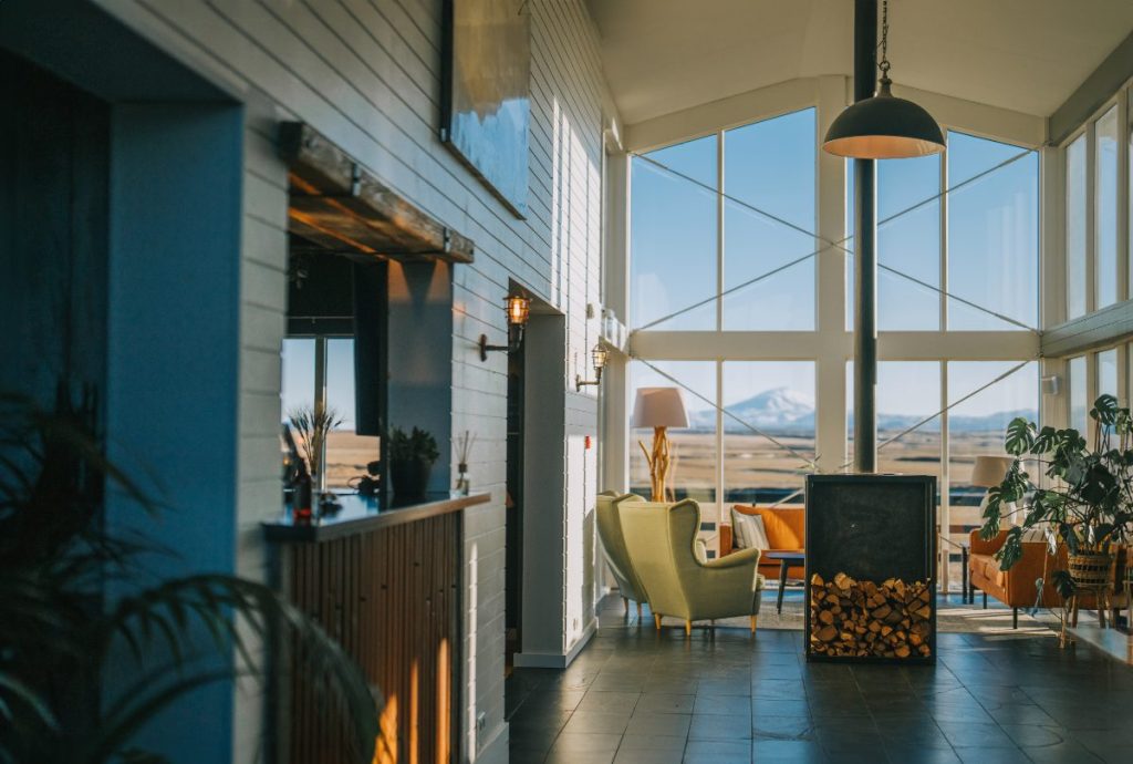 Koselig luksusresort med peis og snødekte fjell i bakgrunnen, Island.