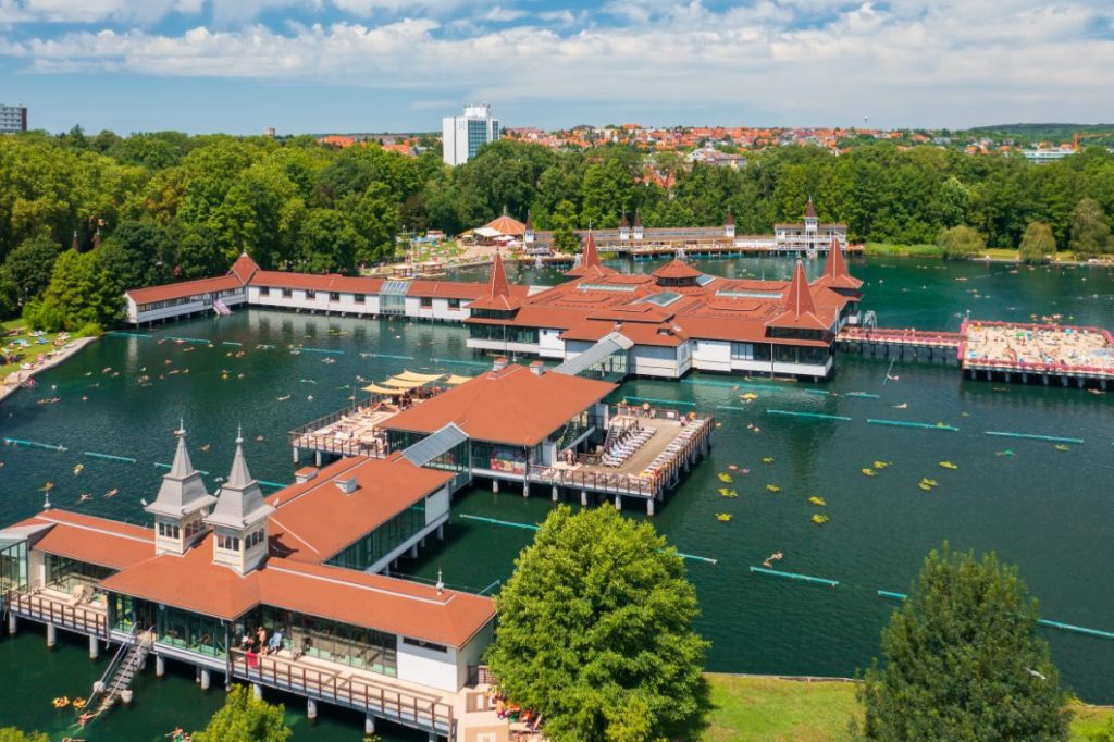 Hévíz termalbad med dampende vann omgitt av grønn vegetasjon.