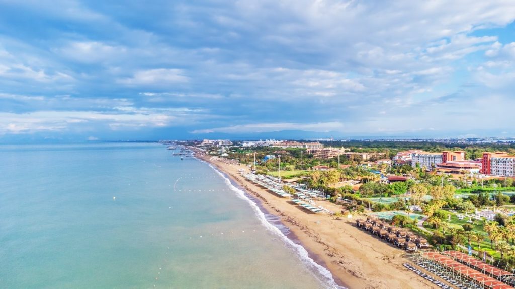 Strand møter turkisblått hav langs tyrkisk riviera.