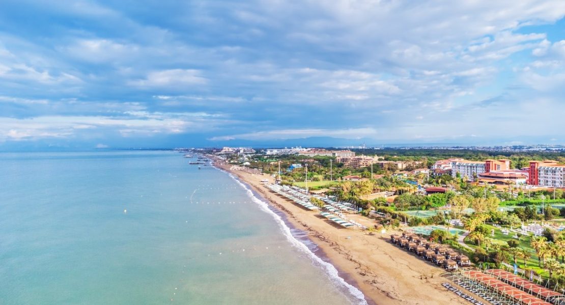 Strand møter turkisblått hav langs tyrkisk riviera.