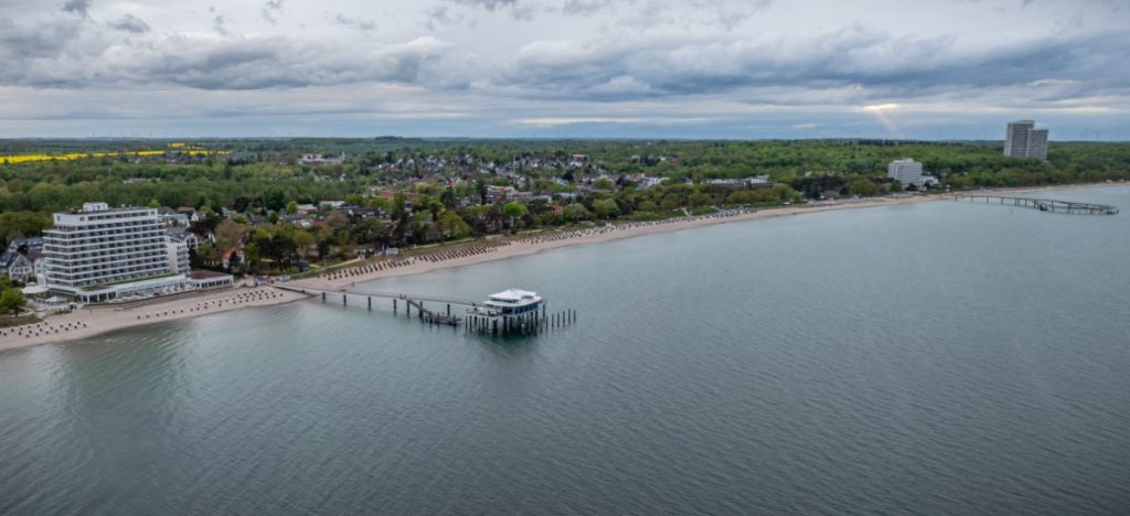 Timmendorfer Strand med strandkurver og lang molo ved Østersjøen.