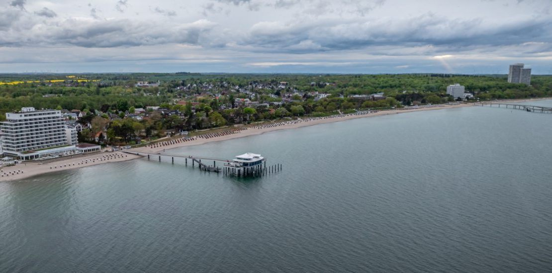 Timmendorfer Strand med strandkurver og lang molo ved Østersjøen.