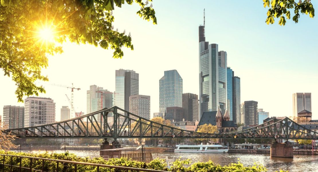 Frankfurts skyskrapere badet i gyllen kveldssol langs Main-elven.