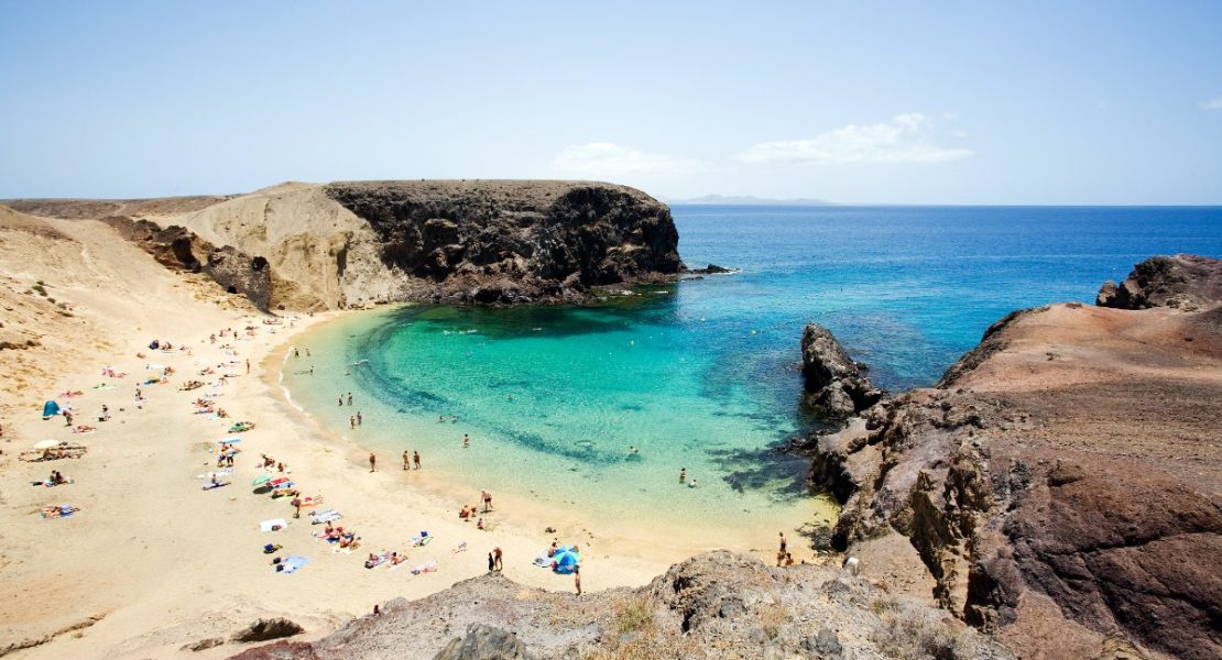 Turkisblått vann møter vulkansk kyst ved Papagayo, Lanzarote.